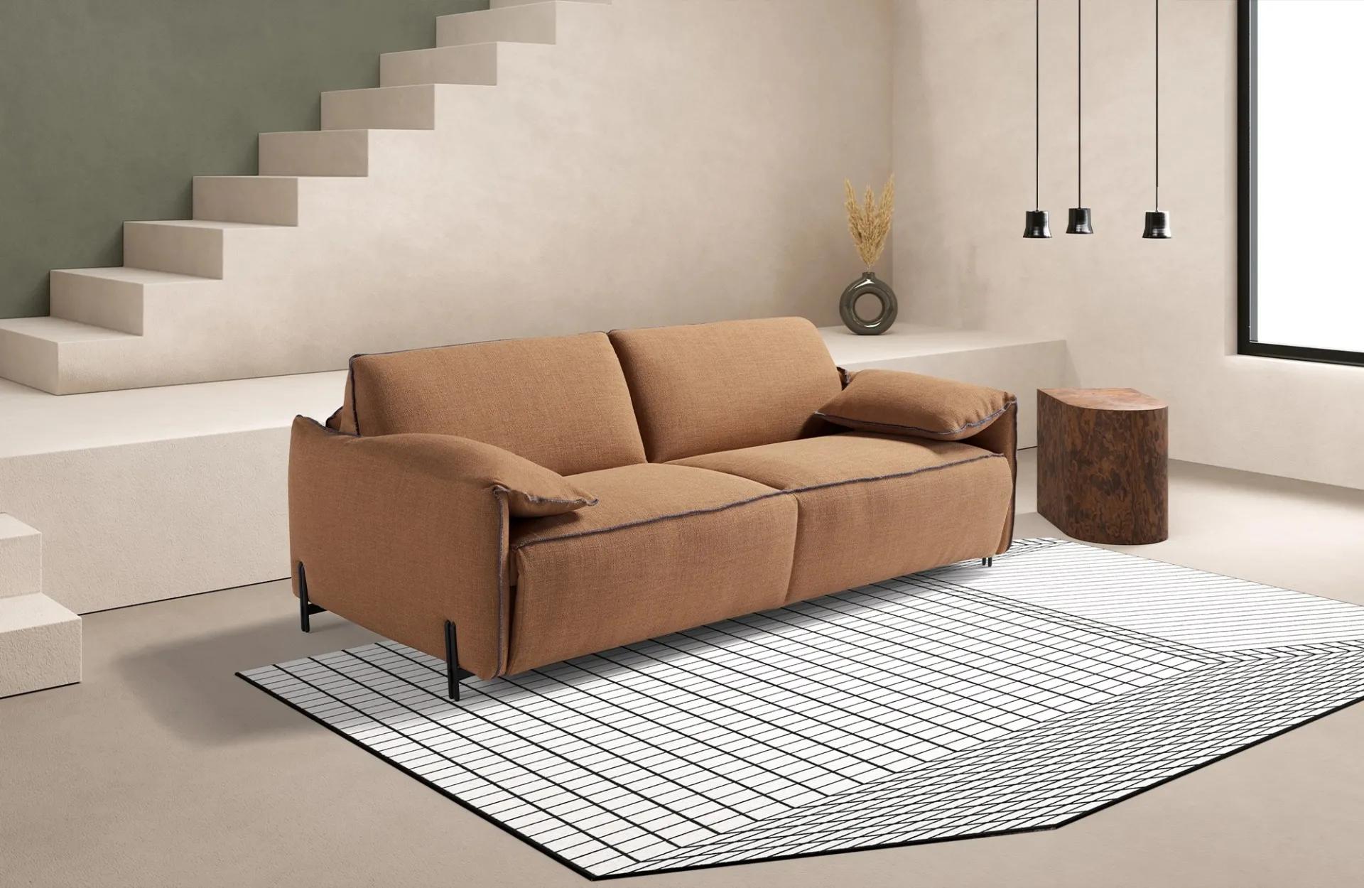 Divano letto Cloud Dienne color cammello sotto una scala, con tappeto a griglia