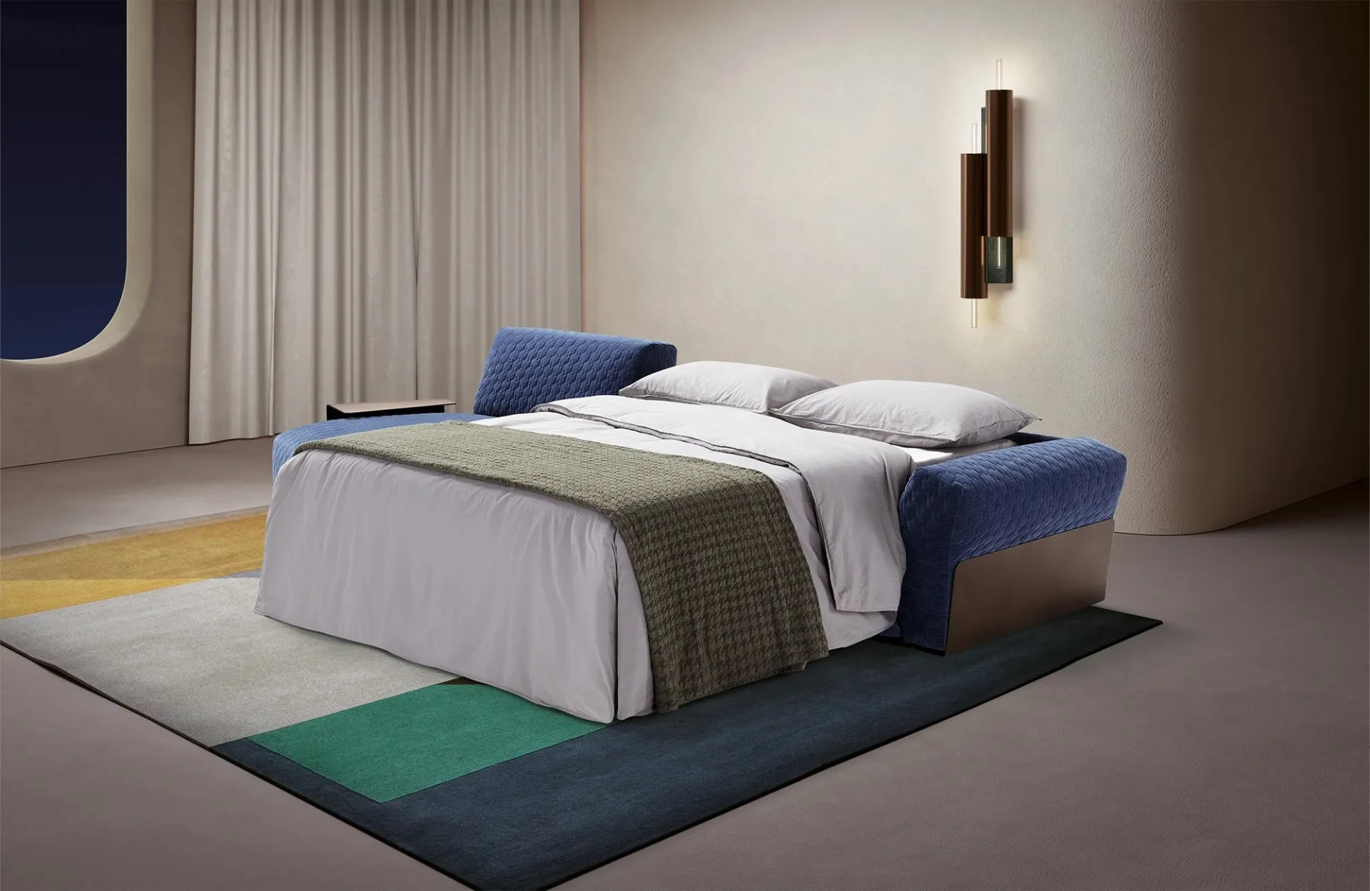 Divano letto Bubble Dienne aperto di sera con coperta verde