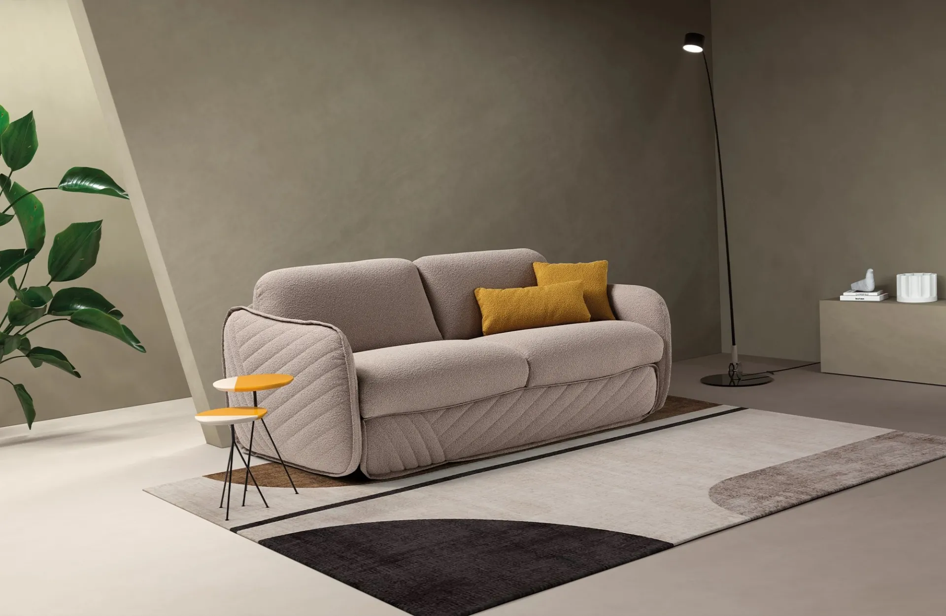 Divano letto Moon Dienne grigio tortora con cuscino senape, accanto a una lampada ad arco
