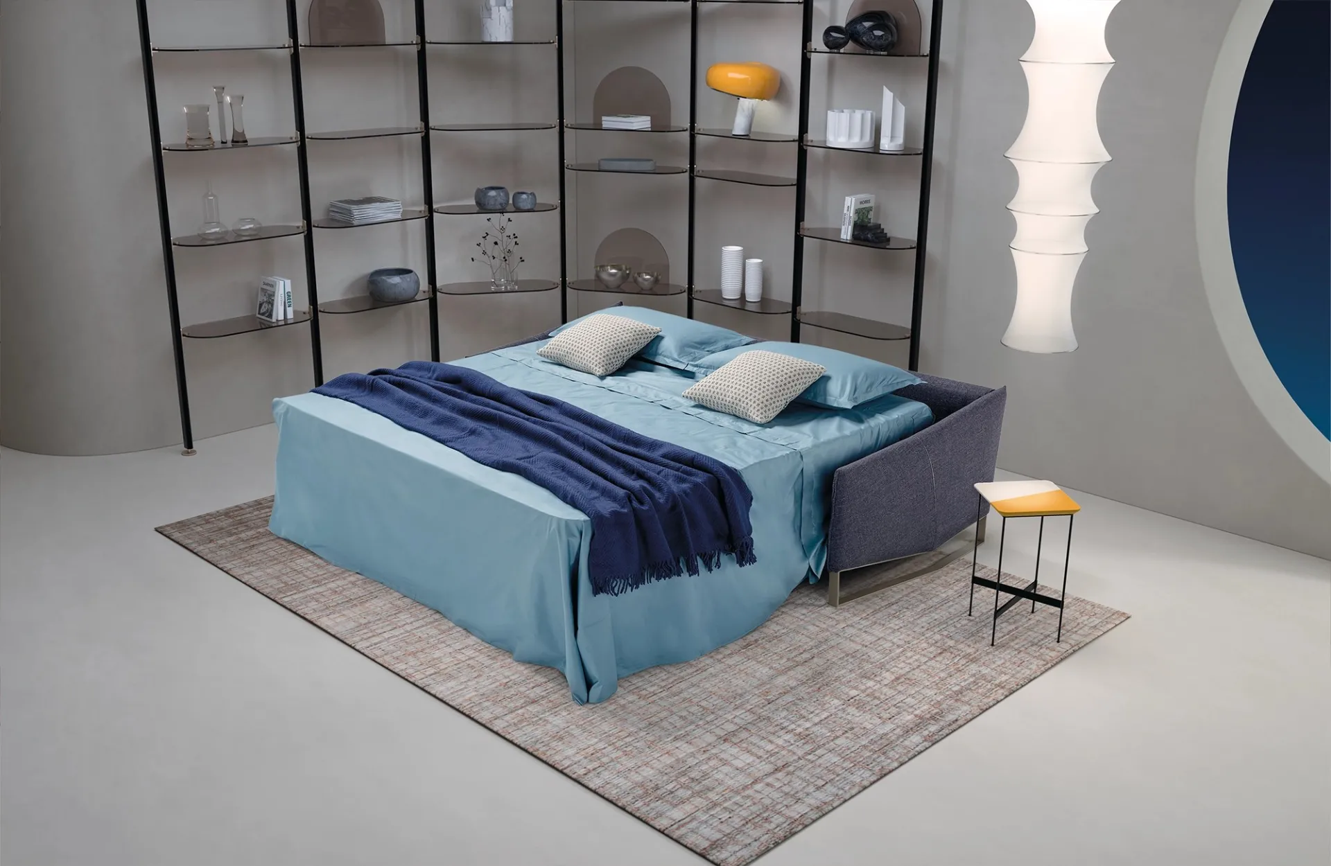 Divano letto Nice Dienne aperto con lenzuola azzurre e coperta blu