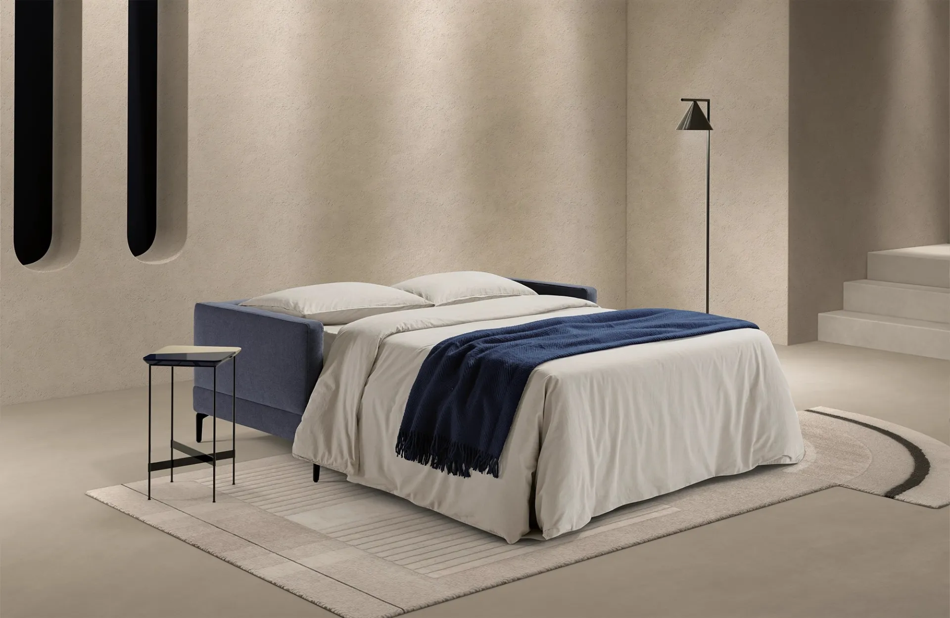 Divano letto Evo Dienne aperto con lenzuola chiare e coperta blu