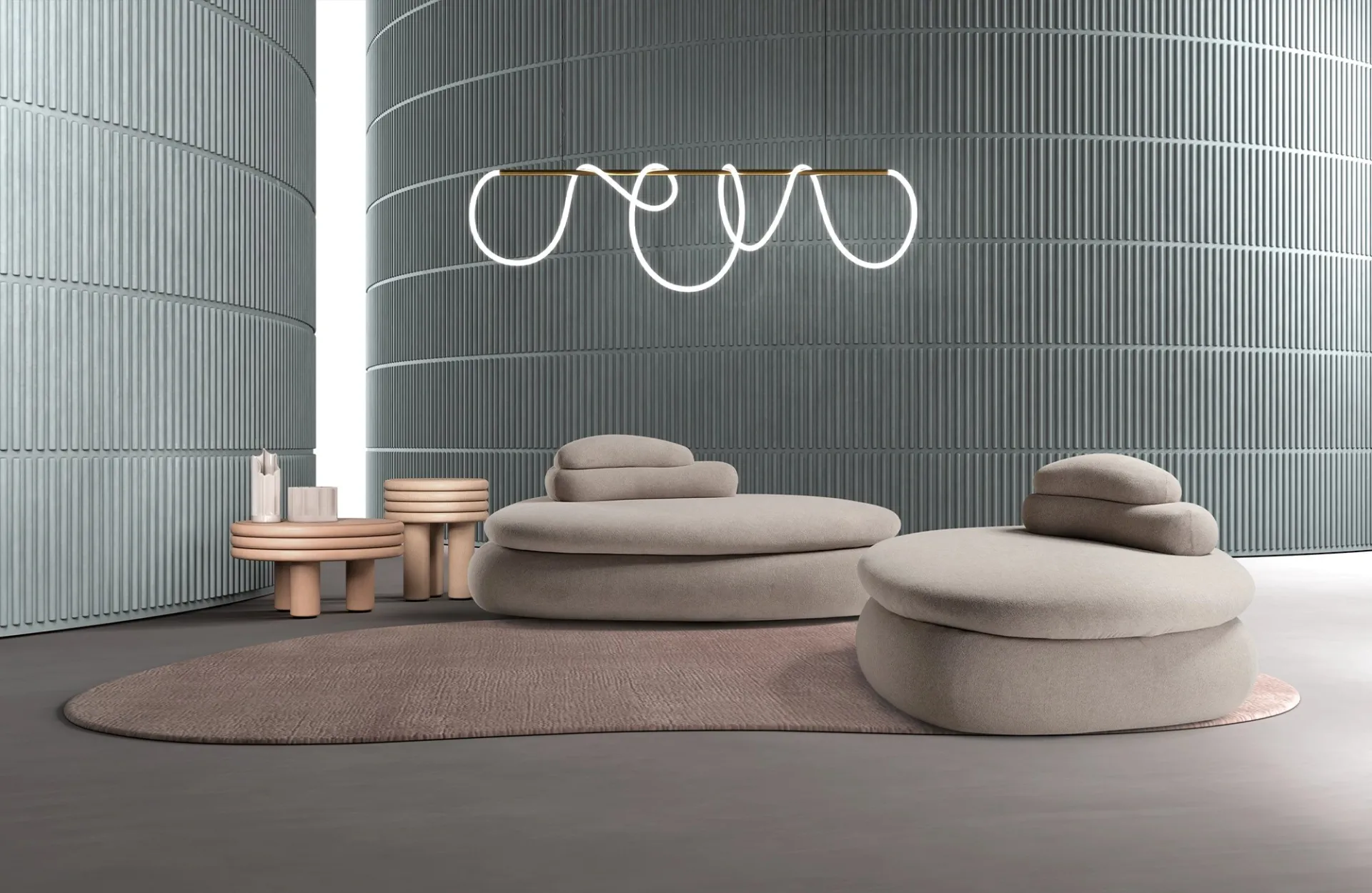 Due pouf letto Petra Dienne a forma di ciottolo color sabbia con schienali volanti, su un tappeto rosa