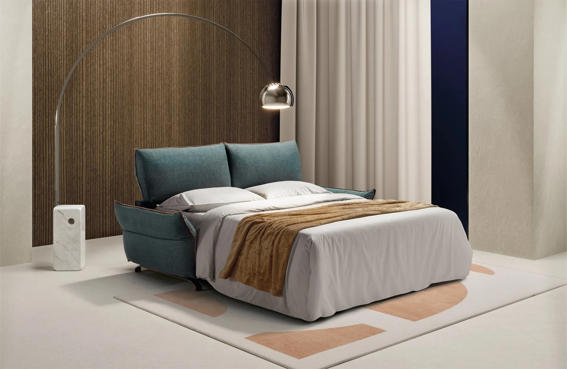 Divano letto Alpi Dienne aperto con lenzuola bianche e plaid ocra