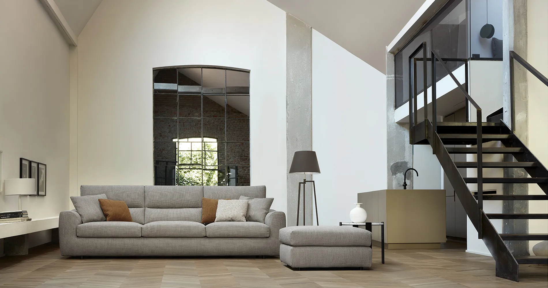 Divano componibile Roma Rosini grigio chiaro con pouf in un soggiorno alto