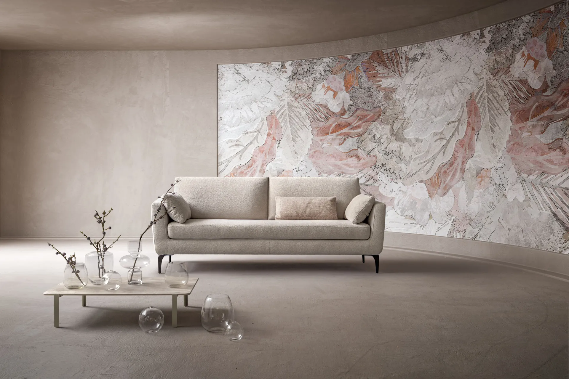Divano Crisp Samoa a tre posti chiaro davanti a una parete curva con decoro floreale