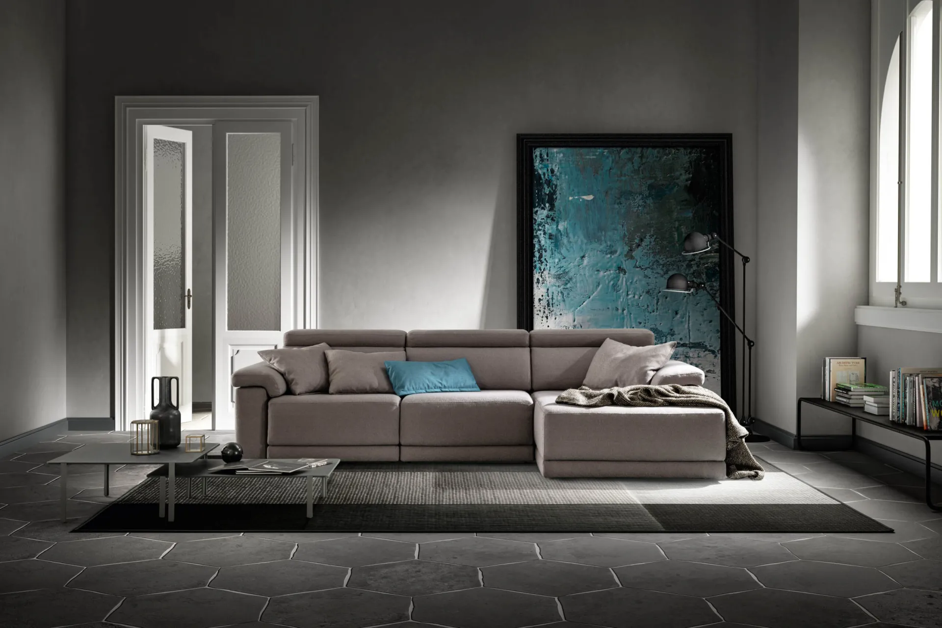 Divano Comfort Samoa grigio talpa con penisola in un salotto con quadro azzurro