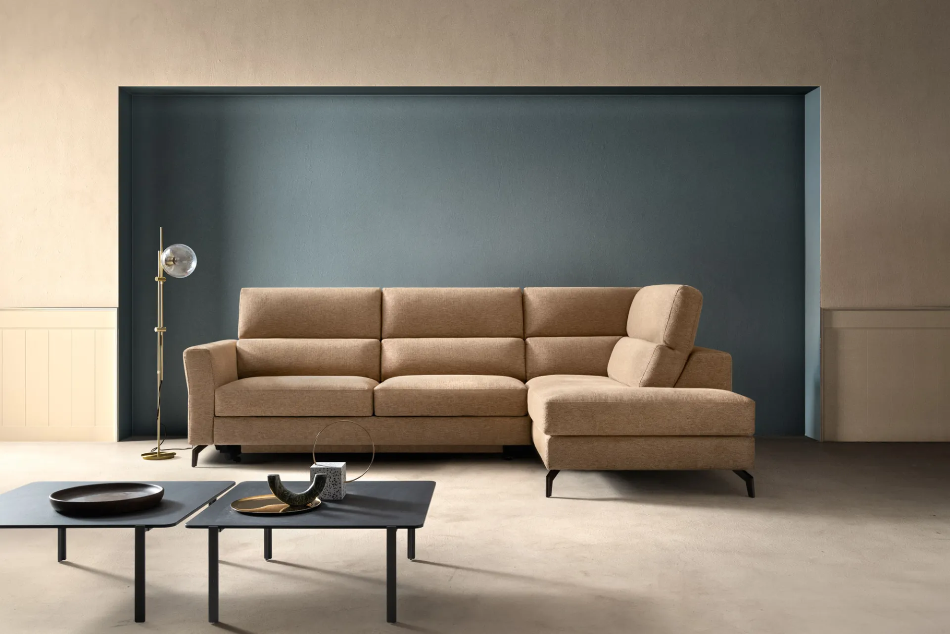 Divano Space Spark Samoa color cammello ad angolo davanti a una nicchia blu