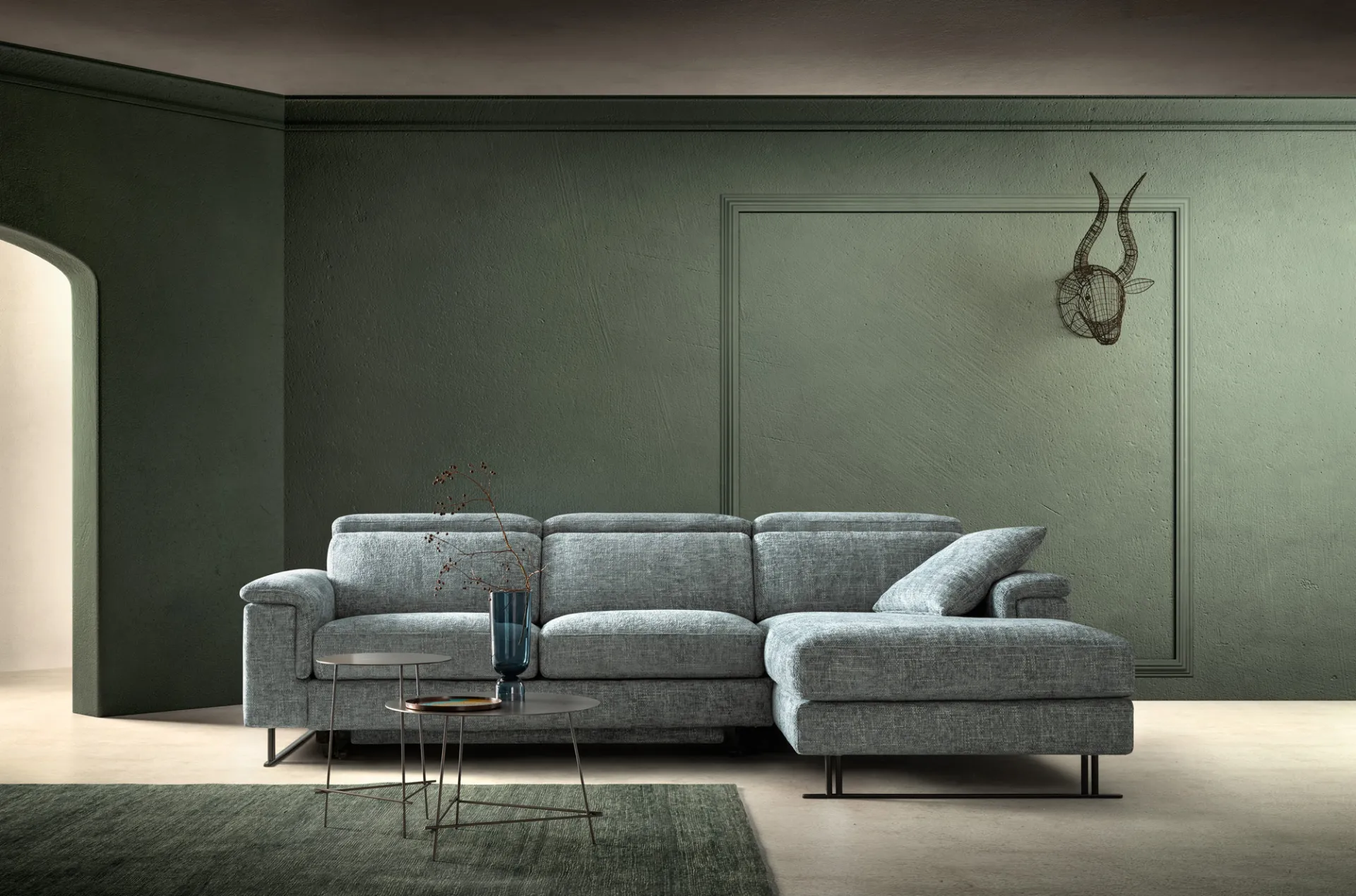 Divano Space Time Samoa grigio azzurro con chaise longue in una stanza dalle pareti verdi