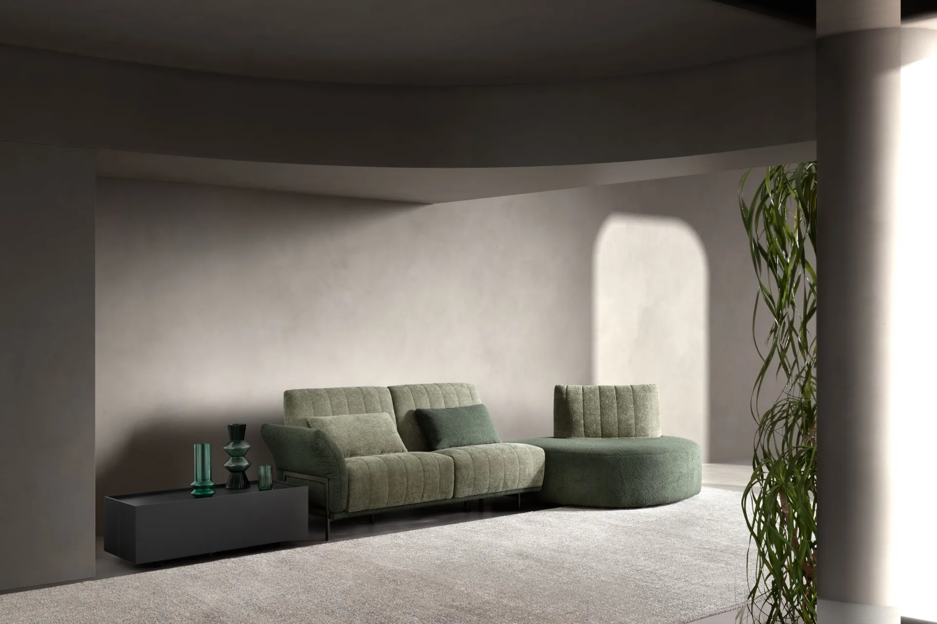 Divano Blank Samoa verde salvia con elemento terminale arrotondato, in una stanza dalle pareti curve