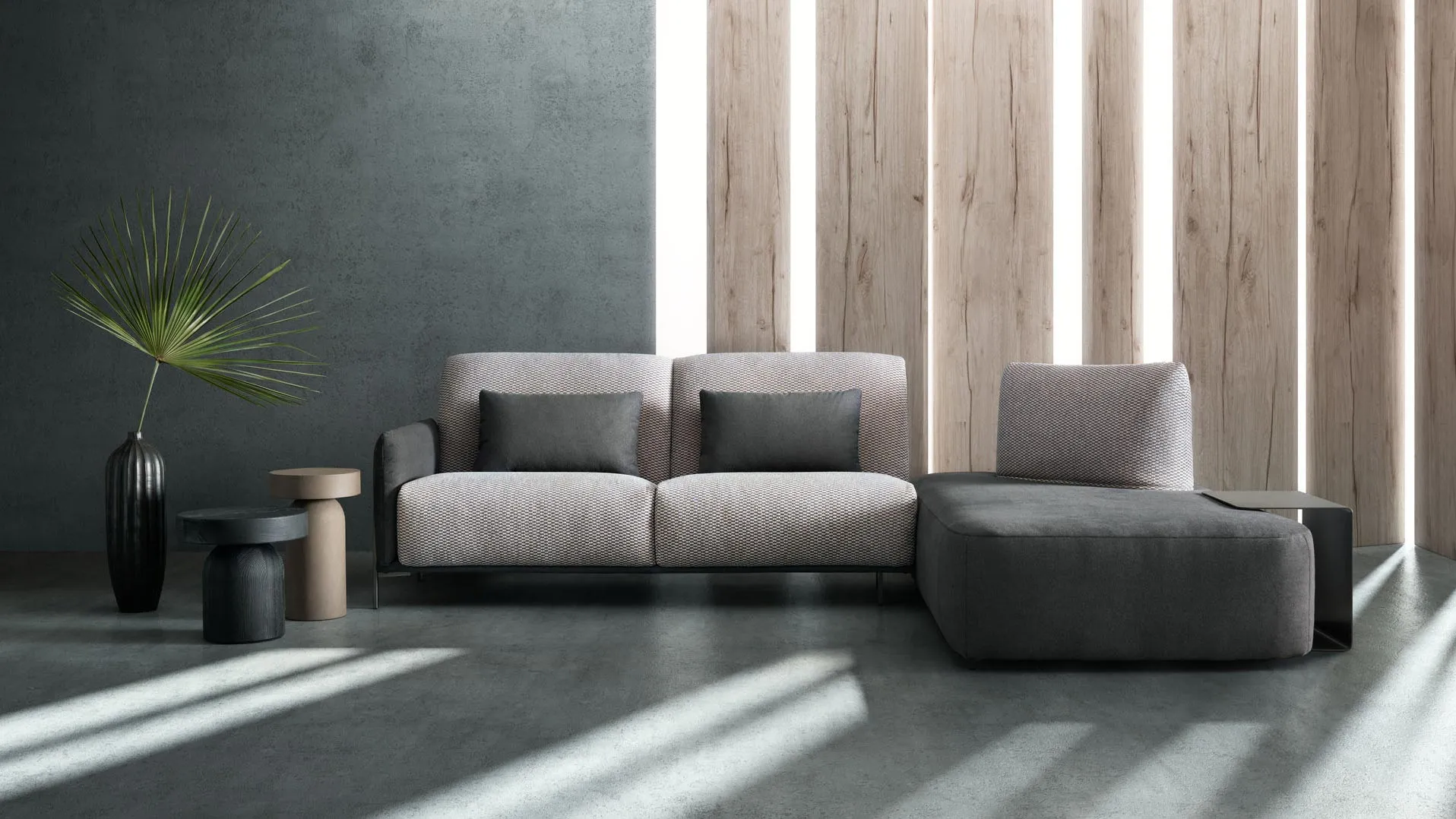 Divano Blank Samoa grigio chiaro lineare accostato a un pouf antracite, con pannelli in legno sullo sfondo