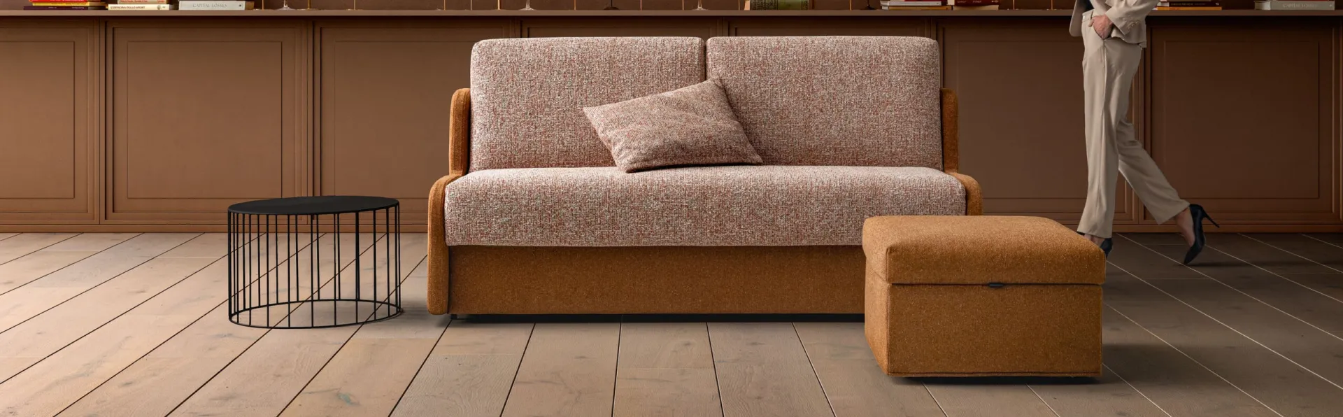 Divano letto Climb Samoa ocra con cuscini rosati e pouf abbinato