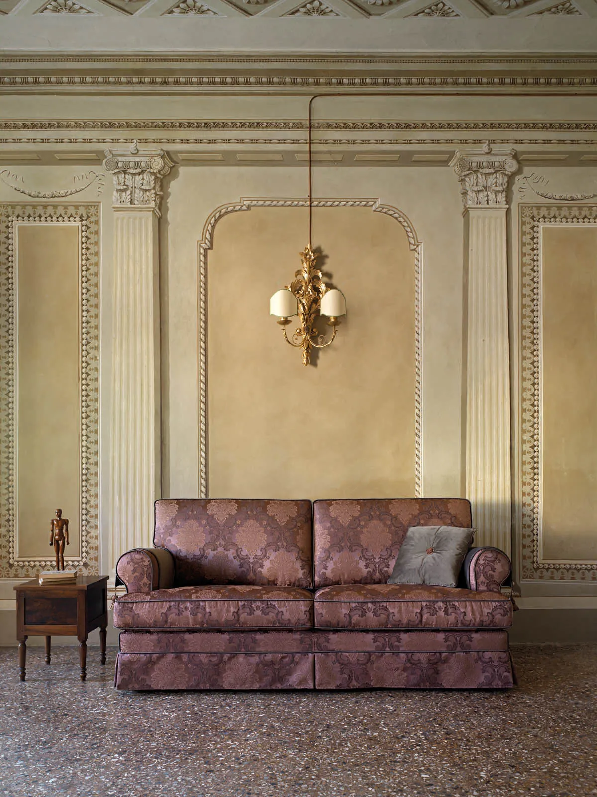 Divano Atena Samoa rosa antico damascato davanti a una parete decorata