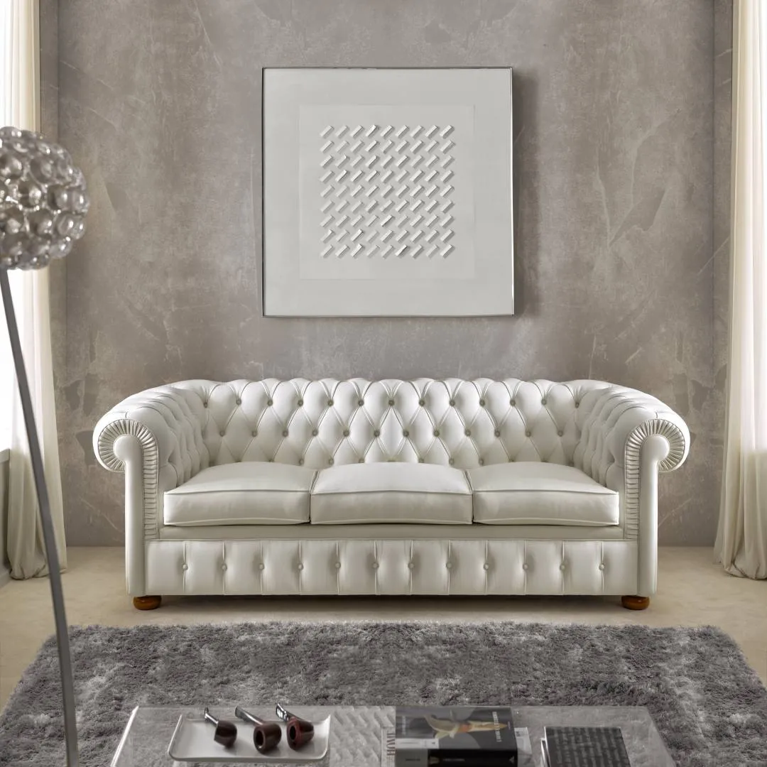 Divano Chesterfield tre posti Tosato 53.09 in pelle bianca capitonné sotto un quadro bianco
