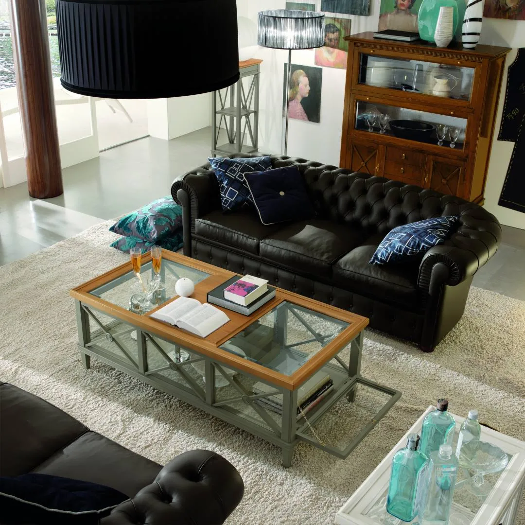 Chesterfield tre posti Tosato in pelle nera con cuscini blu dietro un tavolino in vetro