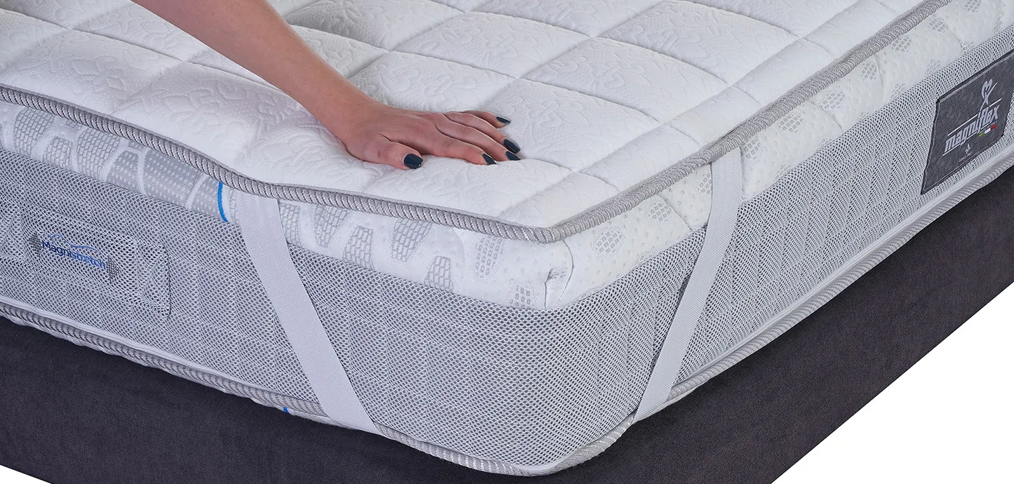 Mano appoggiata sul Topper Classico Traditional Memoform Magniflex fissato con l'elastico