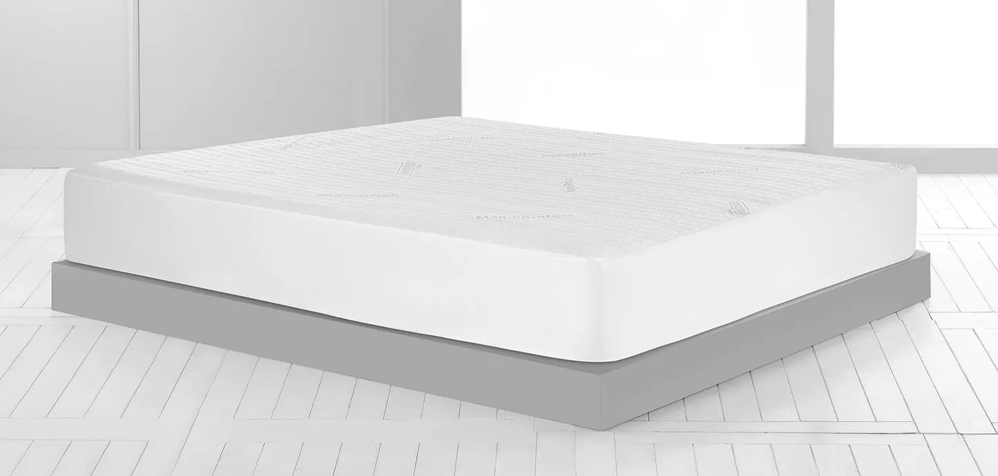 Coprimaterasso MagniProtect Plus Extra Magniflex su un materasso alto in una stanza chiara