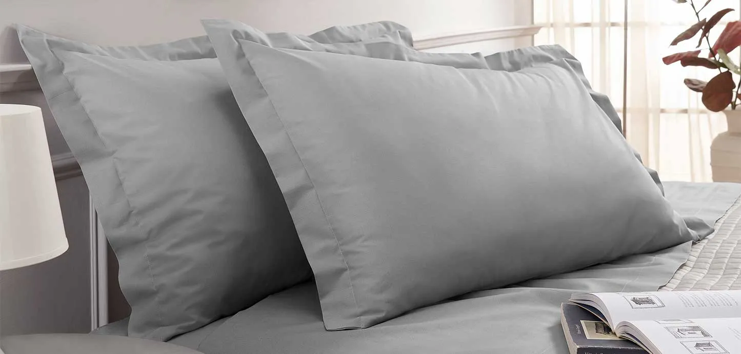 Letto con lenzuola e federe Sogno Magniflex grigie in una camera luminosa