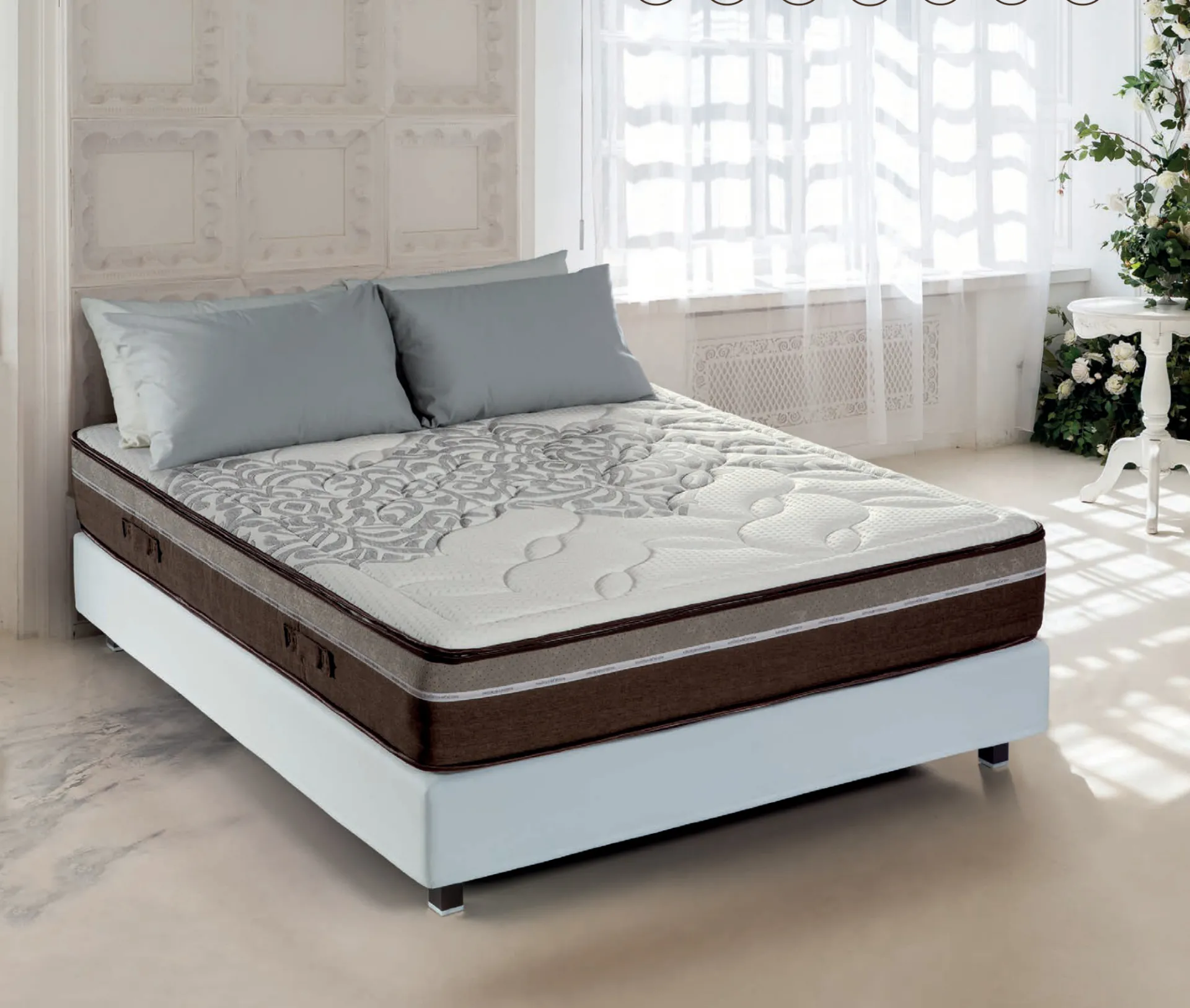 Materasso Personal Manifatture dell'Adriatico con fascia marrone su letto bianco in camera luminosa