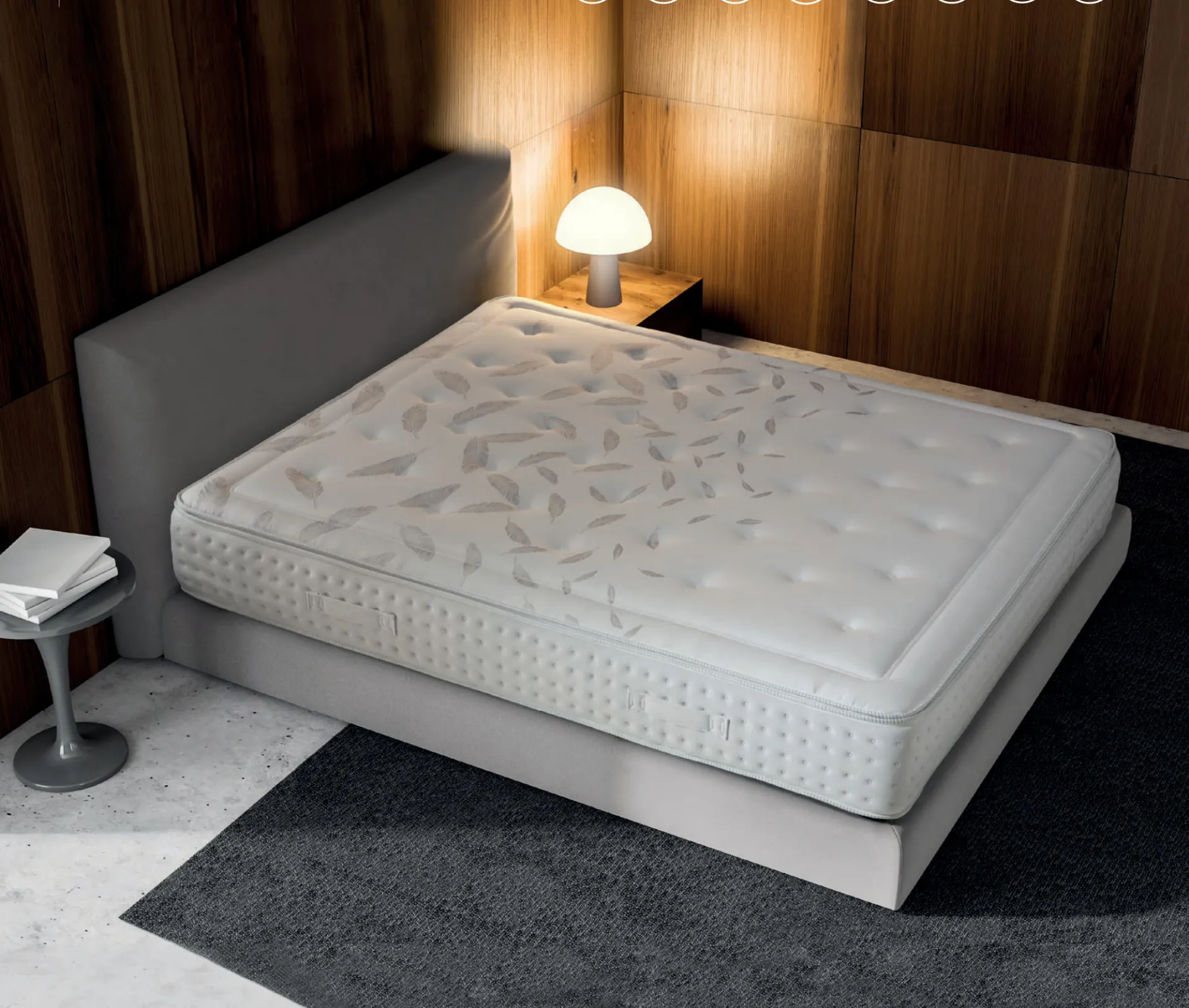 Materasso Luxor Manifatture dell'Adriatico trapuntato a foglie su letto grigio con parete in legno