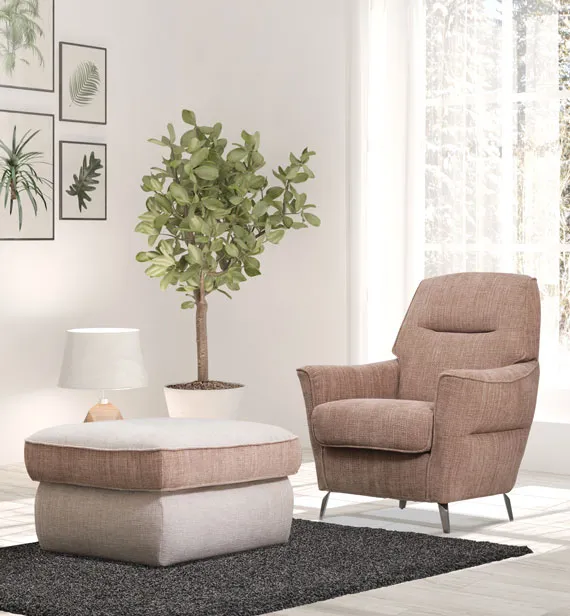 Poltrona Euphoria Aerre Divani rosa antico accanto a un pouf in un ambiente luminoso