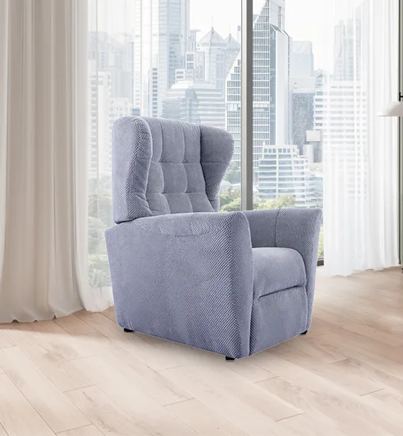 Poltrona relax Celine Aerre Divani azzurro polvere davanti a una vetrata sulla città