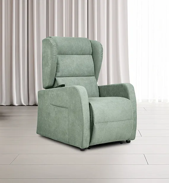 Poltrona relax Marzia Aerre Divani verde salvia davanti a una finestra con tende