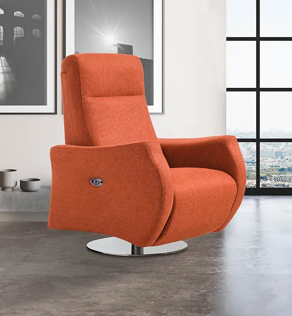 Poltrona relax Cora Aerre Divani arancio con base rotonda in un loft con vetrata