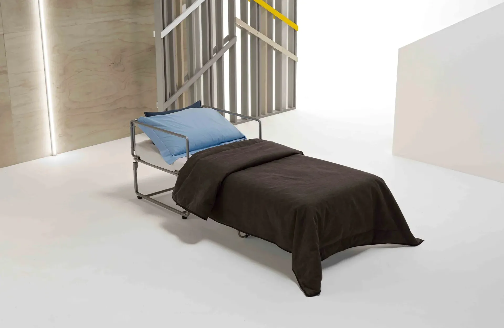 Poltrona letto Loulou Dienne aperta come letto singolo con coperta marrone