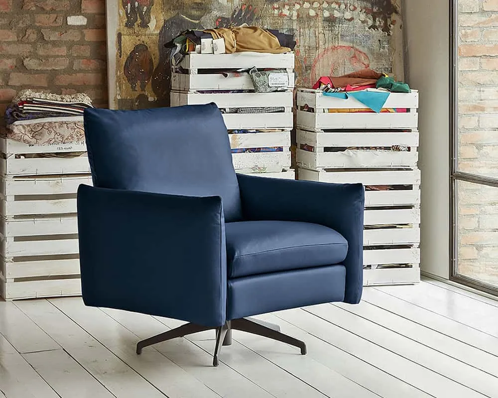 Poltrona London Rosini blu su base in metallo davanti a uno scaffale
