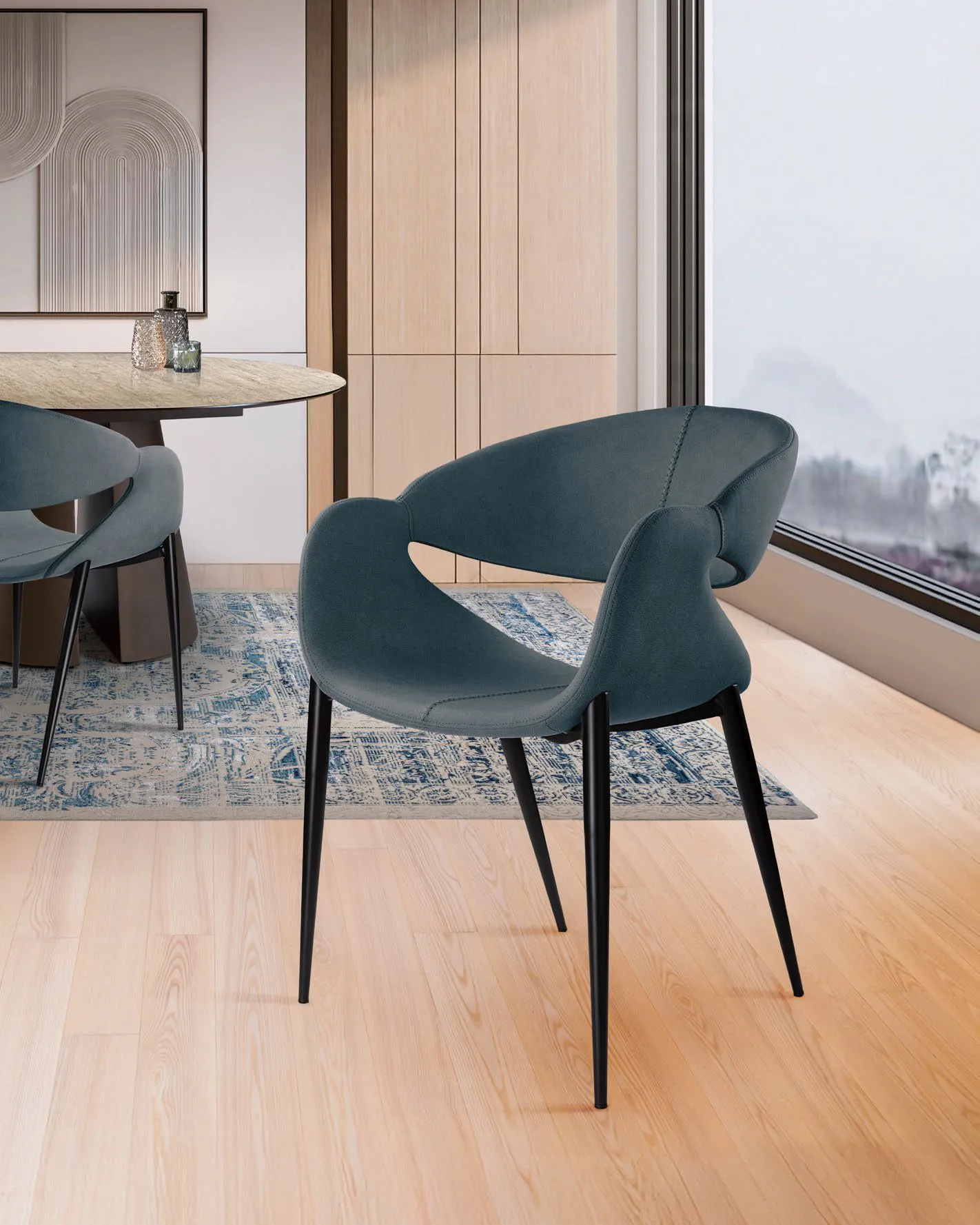 Poltroncina Giro Schuller blu scuro accanto a un tavolo da pranzo